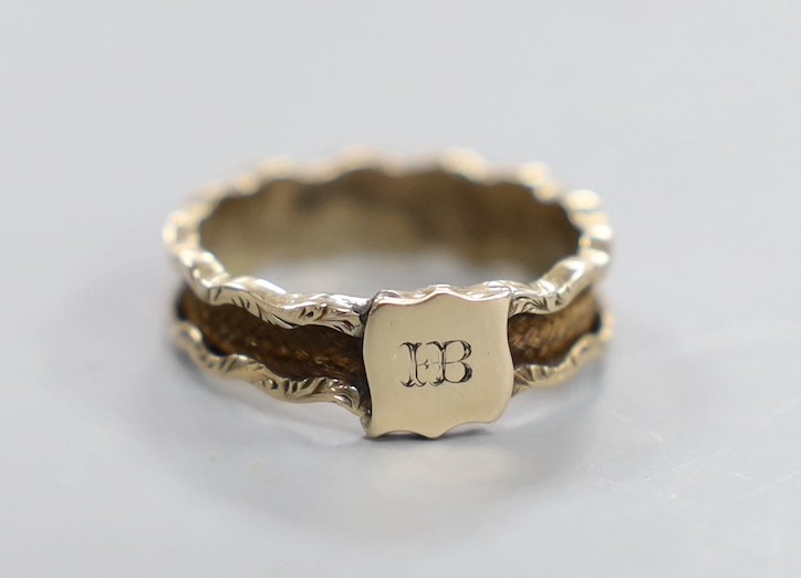 A 19th century yellow metal and plaited hair set band, the ring head with engraved monogram, size M/N, gross weight 1.8 grams.